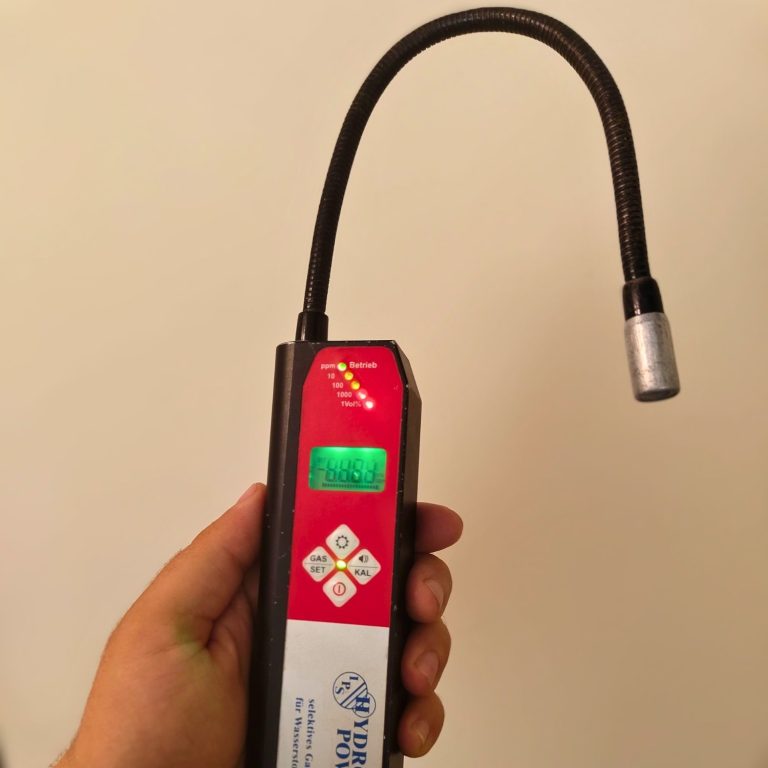 Hand hält Gas-Spürgerät